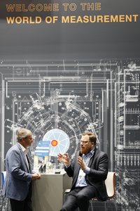 Fachgespräch zwischen Experten in technischer Messe-Umgebung.
